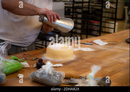 Eine selektive Aufnahme eines Bäckers, der einen Kuchen mit schmückt Marzipan mit der norwegischen Flagge in Waagan Stockfoto