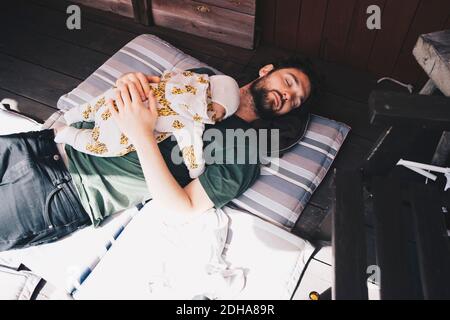 Blick auf Vater und Jungen, die schlafen Kissen in der Ferienvilla Stockfoto