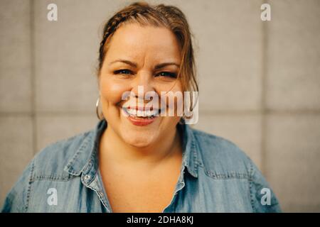 Porträt einer lächelnden Frau an der Wand Stockfoto