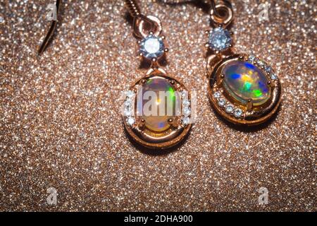 Mode goldene Ohrringe mit einem hellen Regenbogen Blitz Opal Stein. Stockfoto