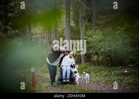 Junge männliche Hausmeister, die Selfie mit behinderten Frau im Rollstuhl Im Wald Stockfoto