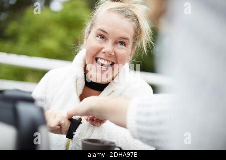 Zugeschnittenes Bild des männlichen Hausmeisters, der die Zeit auf der Armbanduhr von anpasst Behinderte Frau im Hinterhof Stockfoto