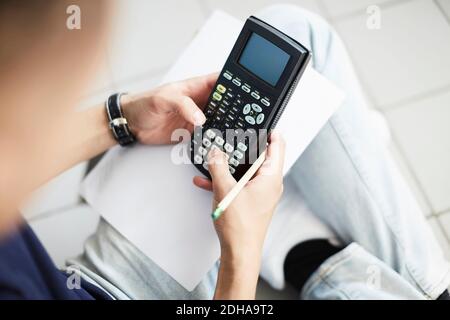 Zugeschnittenes Bild des Mannes mit Rechner während des Studiums im Waschsalon Stockfoto