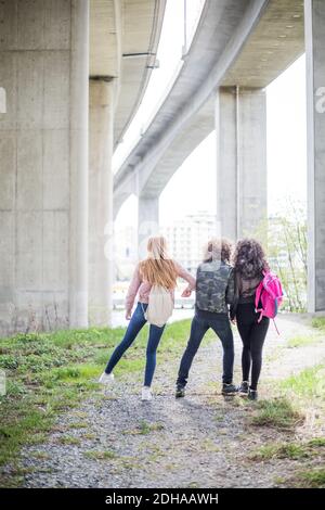 Verspieltes Mädchen schieben Freunde beim Gehen unter Brücke in der Stadt Stockfoto