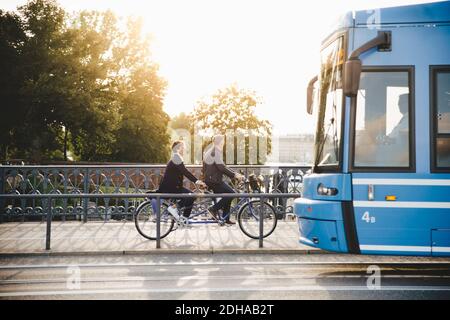 Volle Länge Seitenansicht des älteren Paares Reiten Tandem Fahrrad Auf der Brücke Stockfoto