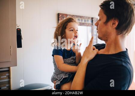 Vater zeigt, während Tochter zu Hause tragen Stockfoto