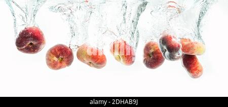 Bündel von Donut Pfirsiche isoliert auf weißem Hintergrund, spritzt in Wasser. Stockfoto
