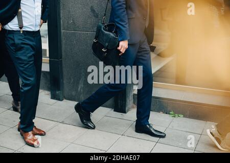 Niedriger Abschnitt von reifen männlichen Geschäftskollegen zu Fuß In der Stadt Stockfoto