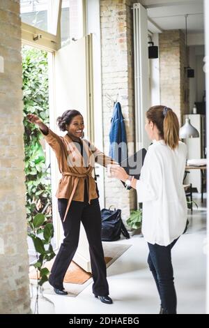 Glückliche Architektin begrüßt Mitarbeiter beim Betreten im Haus Stockfoto
