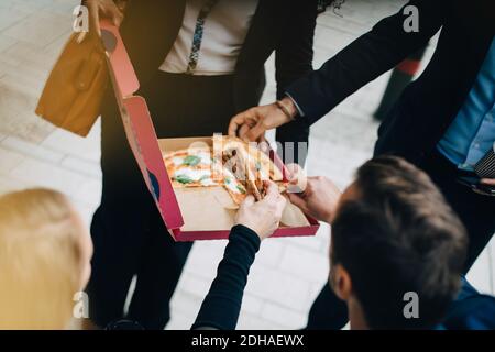 Aus der Perspektive von Kollegen aus der Wirtschaft, die Pizza essen Box in der Stadt Stockfoto