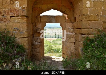 Steineingang Tür des Castillo de Davalillo, in Ruinen, mit einer Landschaft von Weinbergen im Hintergrund. Stockfoto