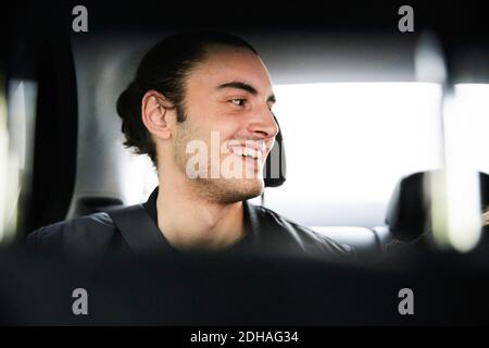 Nahaufnahme eines glücklichen jungen Mannes, der im Auto fährt Stockfoto