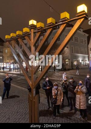 Erfurt, Deutschland. Dezember 2020. Das erste Licht des Chanukka-Lüsters vor dem Erfurter Rathaus leuchtet nach seiner feierlichen Zündung zu Beginn des jüdischen Lichterfestes. Quelle: Michael Reichel/dpa-Zentralbild/dpa/Alamy Live News Stockfoto