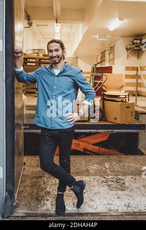 In voller Länge Porträt des lächelnden jungen Geschäftsmann steht in neuen Büro Stockfoto