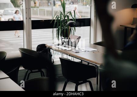 Laptop und Tagebuch auf dem Schreibtisch am Fenster im Kreativbüro Stockfoto
