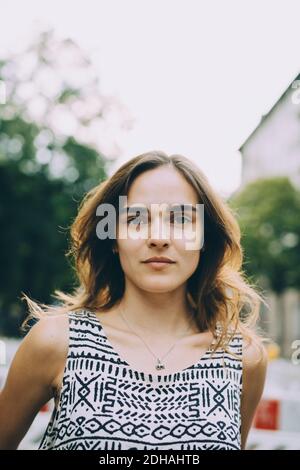 Nahaufnahme Porträt einer jungen Frau mit braunen Haaren gegen den Himmel Stockfoto