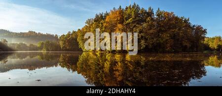 Nebelsee-Landschaft mit Herbstlaub und Baumreflexen in der Steiermark, Thal, Österreich Stockfoto