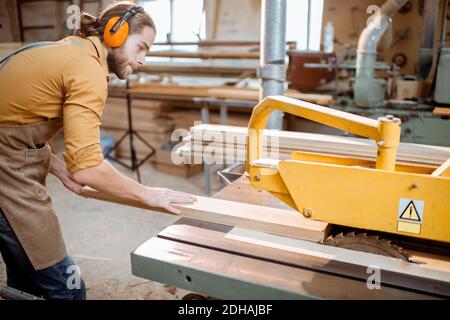 Zimmermannsarbeit Sägen Holzbohlen mit Kreissäge in der Schreinerei-Lager Stockfoto