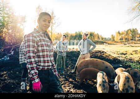 Portrait einer reifen Bäuerin mit Freunden und Schweinen Hintergrund auf Bio-Bauernhof Stockfoto