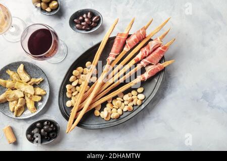 Italienische Antipasti. Grissini, Parma, Artischocken, Oliven, Wein, Schuß von der Oberseite mit Kopie Raum Stockfoto