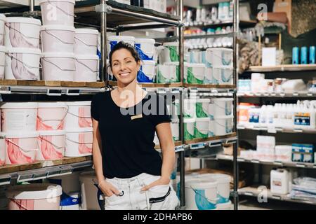 Porträt der lächelnden Verkaufsfrau mit Händen in der Tasche stehen Im Geschäft Stockfoto