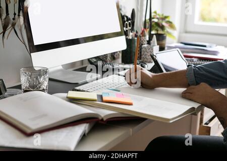 Kurze Hände der Geschäftsfrau Zeichnung auf Buch zu Hause Stockfoto
