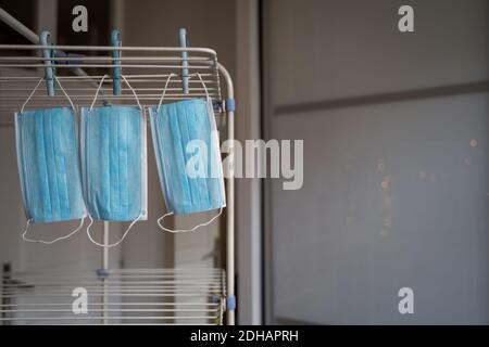Gewaschene Coronavirus chirurgische Gesichtsmasken trocknen auf Wäscheleine. Stockfoto