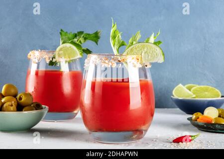 Bloody Mary Cocktails, garniert mit Limette und Sellerie, mit Oliven und Gurken, ein Seitenblick Stockfoto