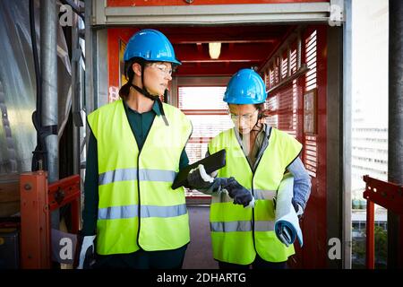 Architektinnen diskutieren beim Spaziergang auf der Baustelle Stockfoto