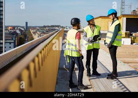 Männliche und weibliche Architekten diskutieren auf Baustelle Stockfoto