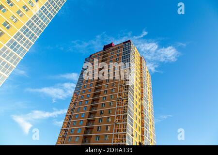 Moderne mehrstöckige Wohngebäude aus Ziegeln und Glas vor dem Hintergrund des Himmels. In braun, beige. Konstruktion. Stockfoto