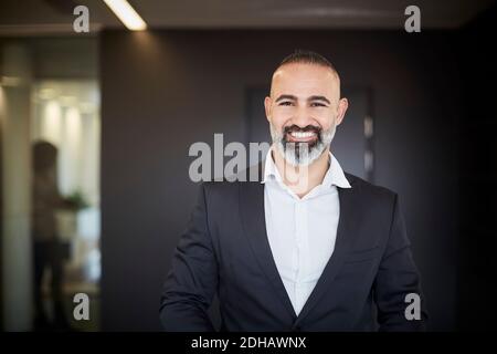 Portrait eines lächelnden, reifen Rechtsanwalts in formellen Standing at Office Stockfoto