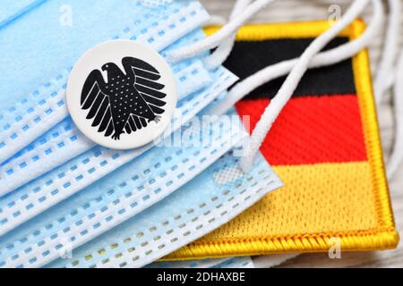 Deutscher Bundesadler, Schutzmasken und deutsche Fahne, Symbolfoto Nationale Gesundheitsreserve Stockfoto