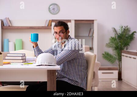 Junger männlicher Architekt, der während einer Pandemie vom Haus aus arbeitet Stockfoto