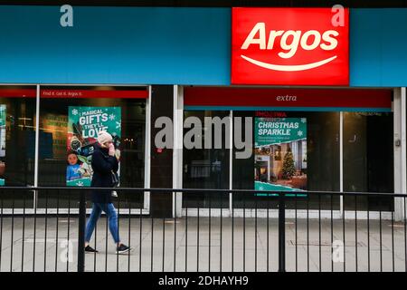 Eine Frau geht an einem Zweig von Argos in London vorbei. Stockfoto