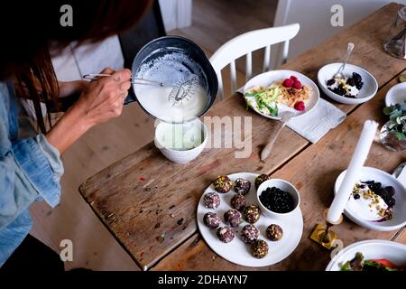 Zugeschnittenes Bild einer Frau, die Matcha-Tee in einer Schüssel zubereitet Tabelle Stockfoto