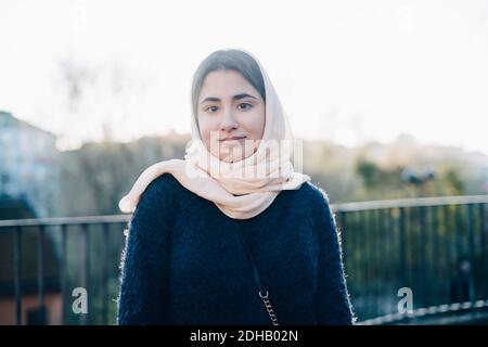 Portrait von selbstbewussten Teenager-Mädchen tragen Hijab Blick weg gegen Himmel Stockfoto