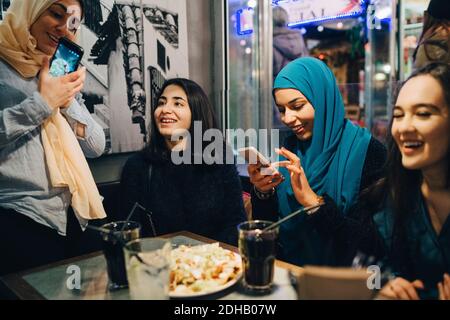 Glückliche multiethnische Freundinnen genießen im Café Stockfoto