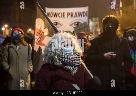 Eine Frau mit Gesichtsmaske hält während der Demonstration eine Fahne mit einem Symbol des Frauenstreiks.Klimaaktivisten organisierten einen Spaziergang für die Erddemonstration in Krakau als Zeichen des Protests gegen das mangelnde Interesse von Politikern am Umweltschutz. Die Teilnehmer hielten Banner zur Unterstützung des Women's Strike. Stockfoto