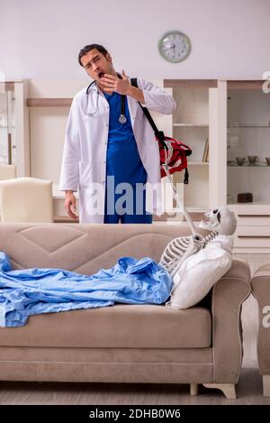 Junger männlicher Sanitäter besucht Skelettpatient Stockfoto