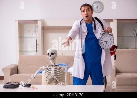 Junger männlicher Sanitäter besucht Skelettpatient Stockfoto