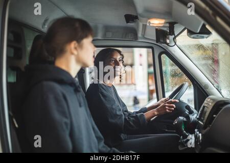 Weibliche Mover Blick in Rückspiegel während der Fahrt LKW Stockfoto