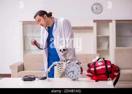 Junger männlicher Sanitäter besucht Skelettpatient Stockfoto