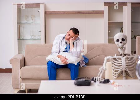 Junger männlicher Sanitäter besucht Skelettpatient Stockfoto