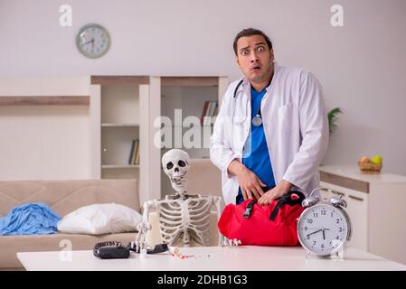 Junger männlicher Sanitäter besucht Skelettpatient Stockfoto