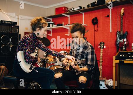 Freunde spielen Gitarren während der Übung im Aufnahmestudio Stockfoto