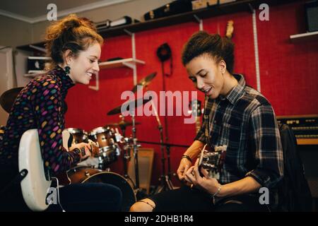 Freunde spielen Gitarren während der Übung im Aufnahmestudio Stockfoto