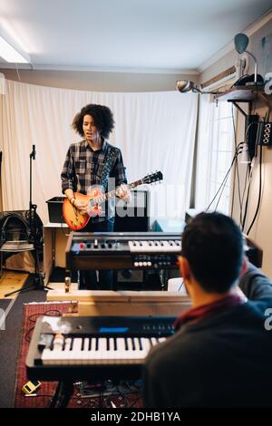 Männliche Freunde spielen Musikinstrumente im Aufnahmestudio Stockfoto