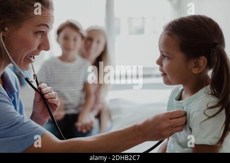 Kinderärztin beim Zuhören des Herzschlags des Mädchens durch Stethoskop in der Klinik Stockfoto