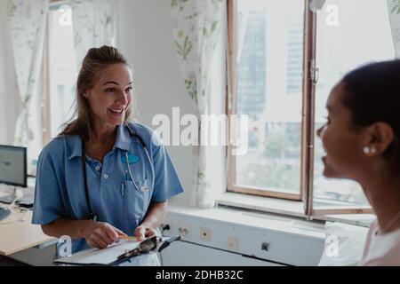 Lächelnde Krankenschwester, die im Krankenhaus mit dem Patienten spricht Stockfoto
